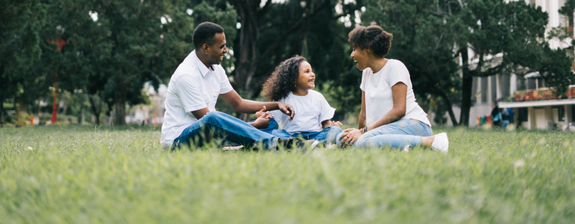Familia sentados en el suelo de un parque