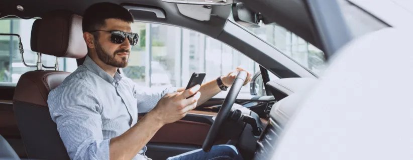 hombre utilizando el celular dentro de un carro