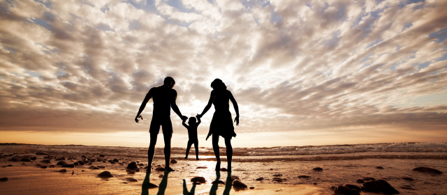 silueta de familia jugando en la playa