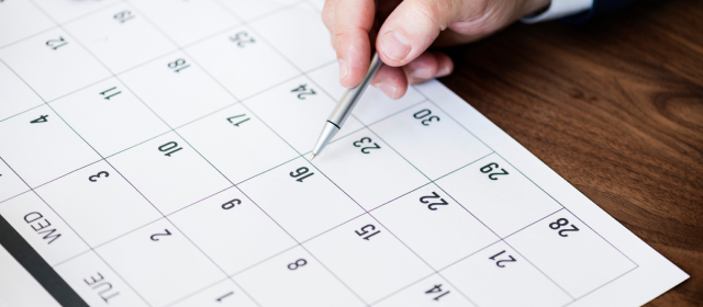 Calendario con una mano señalando una fecha