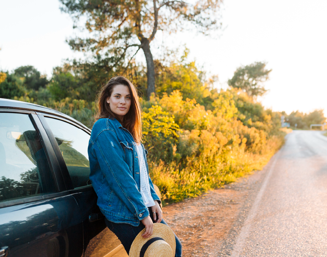 Automóvil sobre una carretera al atardecer con un bosque de fondo